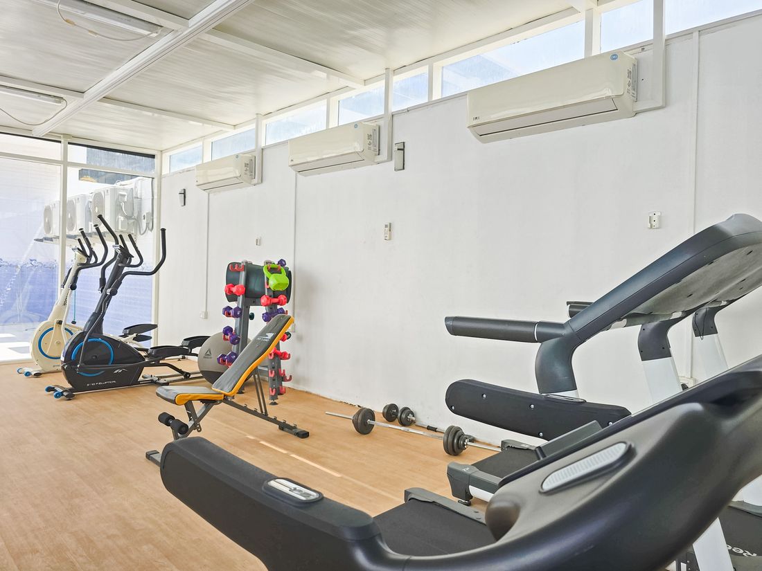 Gym with treadmills, an elliptical trainer, a bench and free weights
